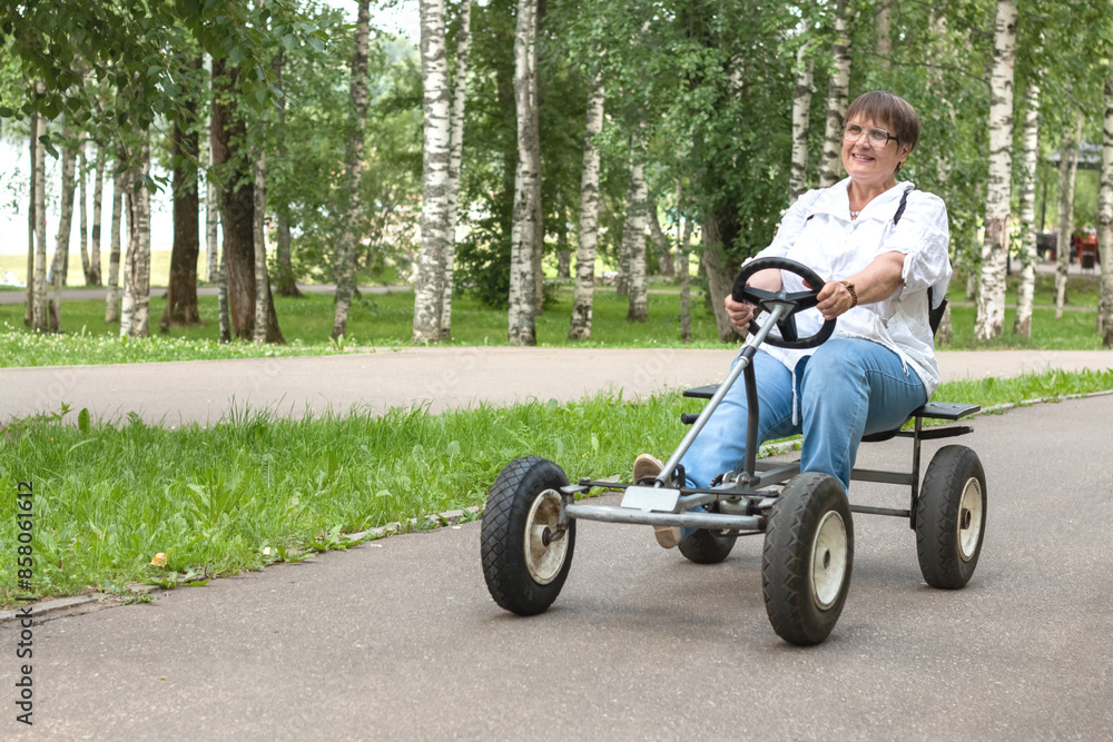 An elderly woman rides a toy car. An elderly woman rides a toy car.