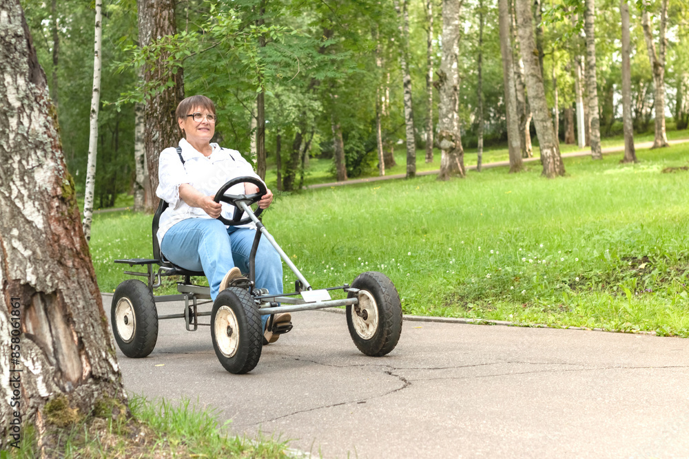 An elderly woman rides a toy car. An elderly woman rides a toy car.