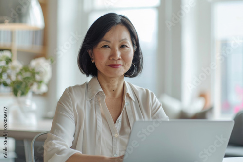 Confident Asian Businesswoman Working on Laptop in Office Setting