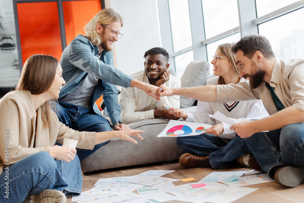 Diverse team giving fist bump celebrating successful project Diverse team giving fist bump celebrating successful project