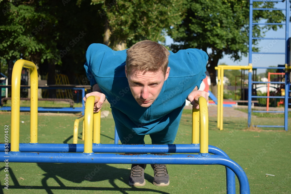 Obraz premium A dedicated young athlete puts in the hard work, vigorously training on gym equipment outdoors to prepare his body. He builds strength and endurance before hitting the field or court for competition
