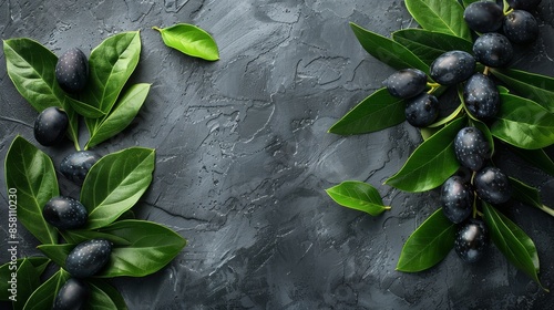 A close-up view of fresh black olives with green leaves arranged on a dark textured background, capturing the essence of fresh, organic, and healthy food ingredients. photo