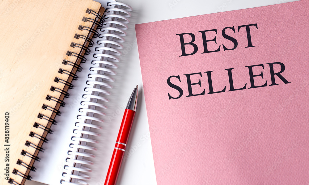 BEST SELLER text on pink paper with notebooks BEST SELLER text on pink paper with notebooks
