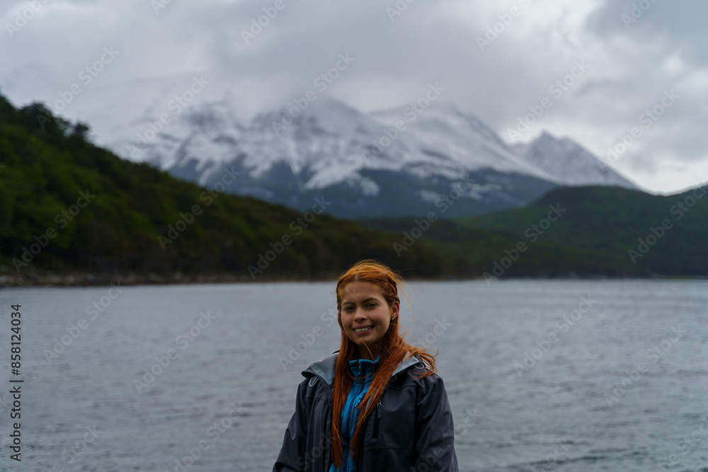 Photo of a pretty young girl in trekking clothes with a smile in front of the Beagle Channel in Tierra del Fuego National Park, Ushuaia, Argentina. Photo of a pretty young girl in trekking clothes with a smile in front of the Beagle Channel in Tierra del Fuego National Park, Ushuaia, Argentina.