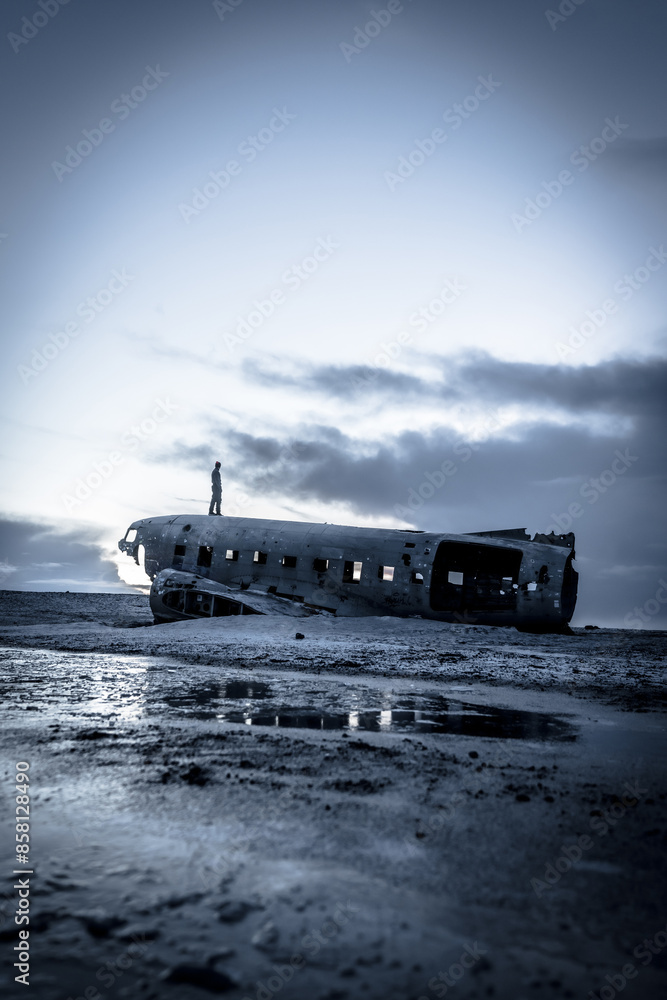 Fototapeta premium A man stands on a beach next to a large
