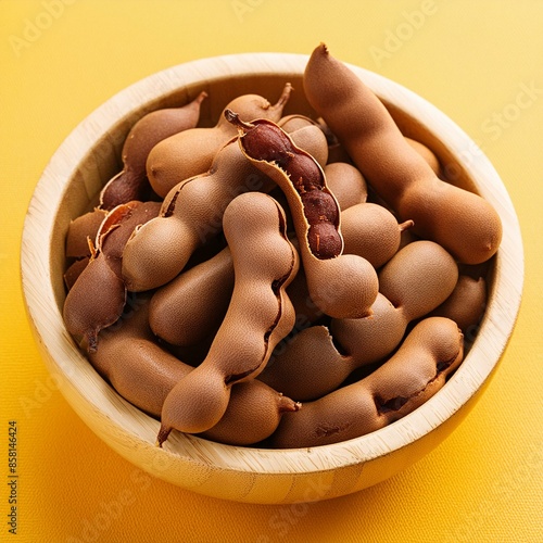 Fresh delicious ripe tamarind on yellow background photo