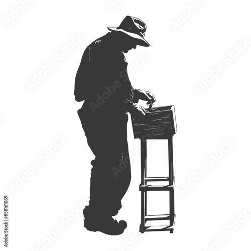 Silhouette of a man with a hat using a box on a stand.