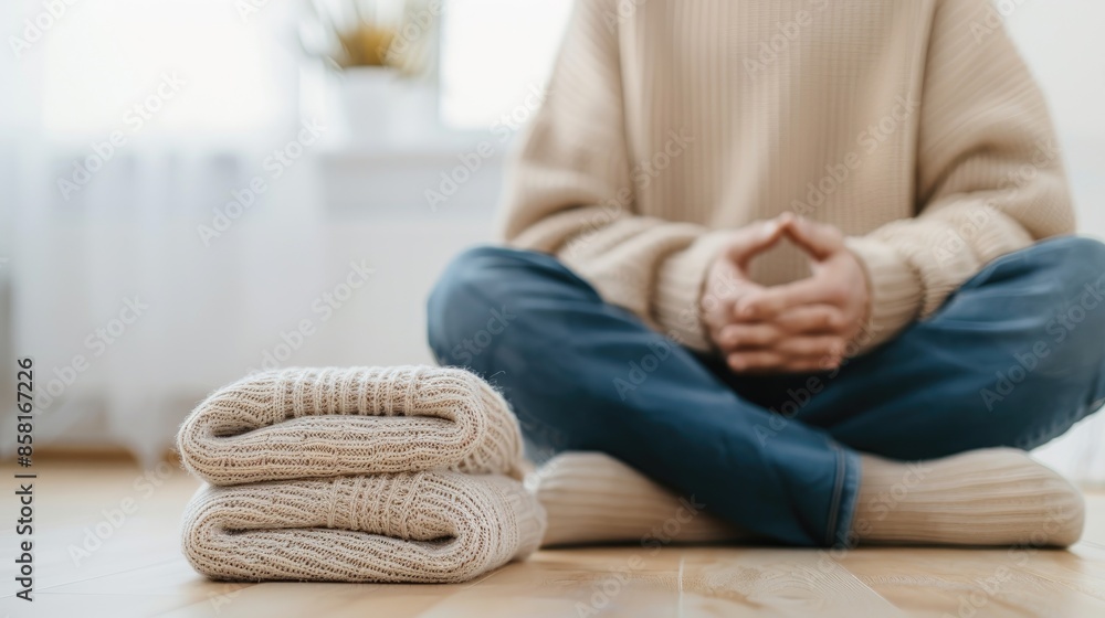 A stack of white towels and beige blankets rest on a white bed in a modern bedroom A stack of white towels and beige blankets rest on a white bed in a modern bedroom