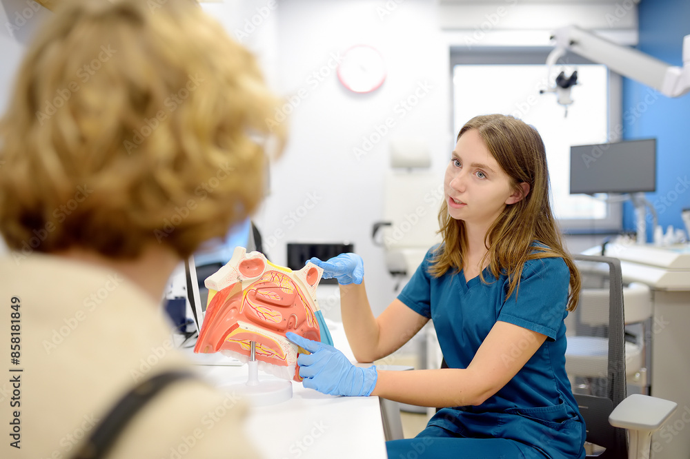 The otolaryngologist explains to the patient about his illness at the appointment. A professional ENT doctor demonstrates a model of the human nose. Treatment of inflammation disease of nose. The otolaryngologist explains to the patient about his illness at the appointment. A professional ENT doctor demonstrates a model of the human nose. Treatment of inflammation disease of nose.