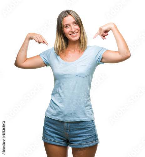 Young beautiful woman over isolated background looking confident with smile on face, pointing oneself with fingers proud and happy.