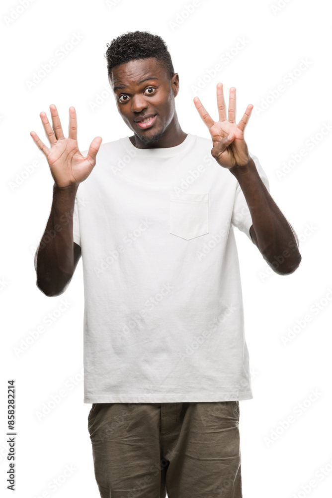 Fototapeta premium Young african american man wearing white t-shirt showing and pointing up with fingers number nine while smiling confident and happy.