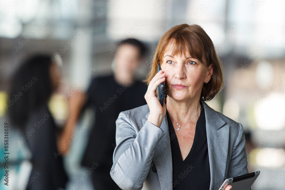 Diverse businesspeople are standing at the building corridor and talking together. Diverse businesspeople are standing at the building corridor and talking together.