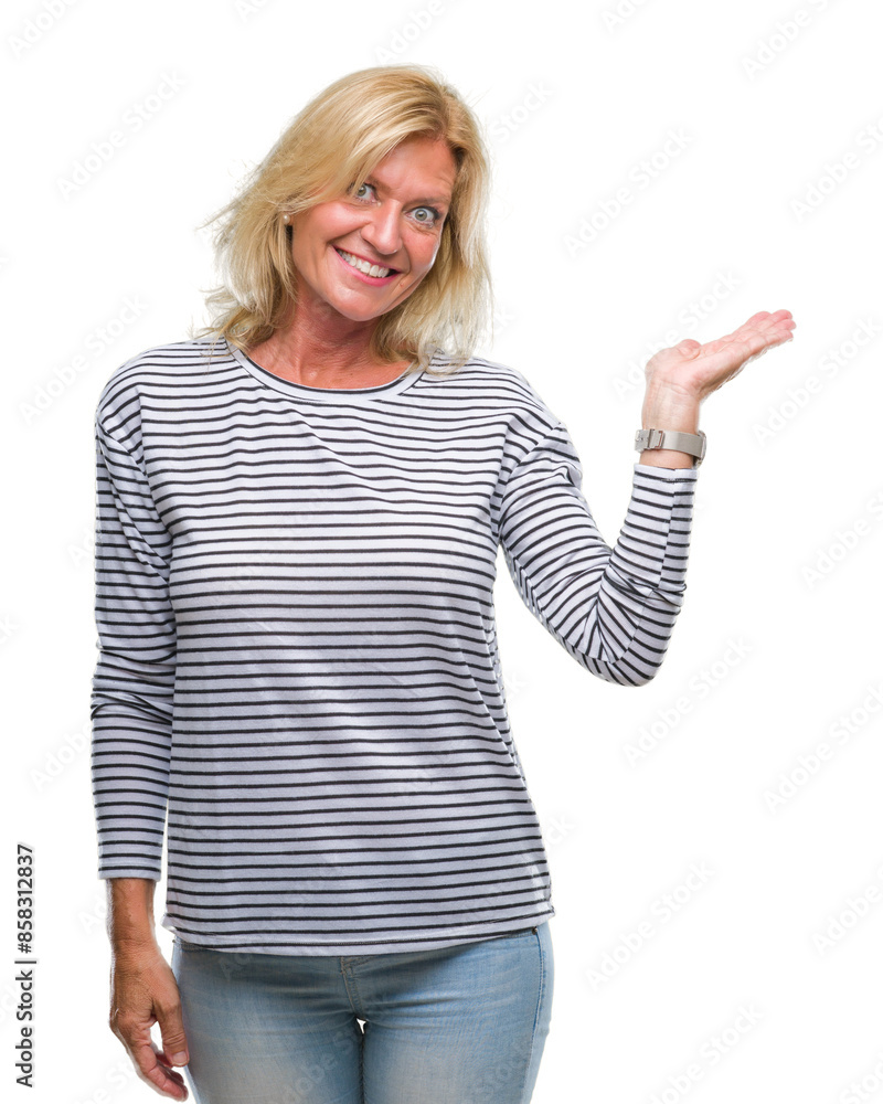 Middle age blonde woman over isolated background smiling cheerful presenting and pointing with palm of hand looking at the camera. Middle age blonde woman over isolated background smiling cheerful presenting and pointing with palm of hand looking at the camera.