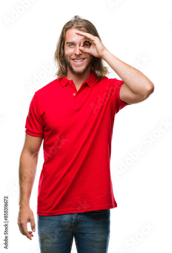 Young handsome man with long hair over isolated background doing ok gesture with hand smiling, eye looking through fingers with happy face.