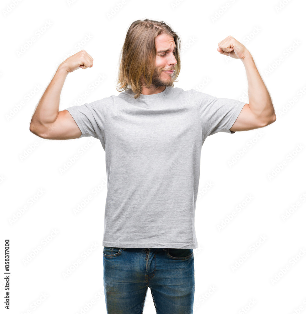 Young handsome man with long hair over isolated background showing arms muscles smiling proud. Fitness concept. Young handsome man with long hair over isolated background showing arms muscles smiling proud. Fitness concept.