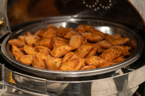 Mini vegan Empanadas at an event in a metal warmer. Very spicy and crunchy food.