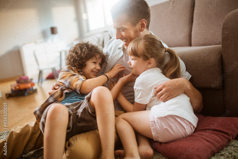 Happy father playing with son and daughter at home Happy father playing with son and daughter at home