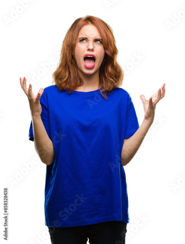 Young beautiful woman over isolated background crazy and mad shouting and yelling with aggressive expression and arms raised. Frustration concept.