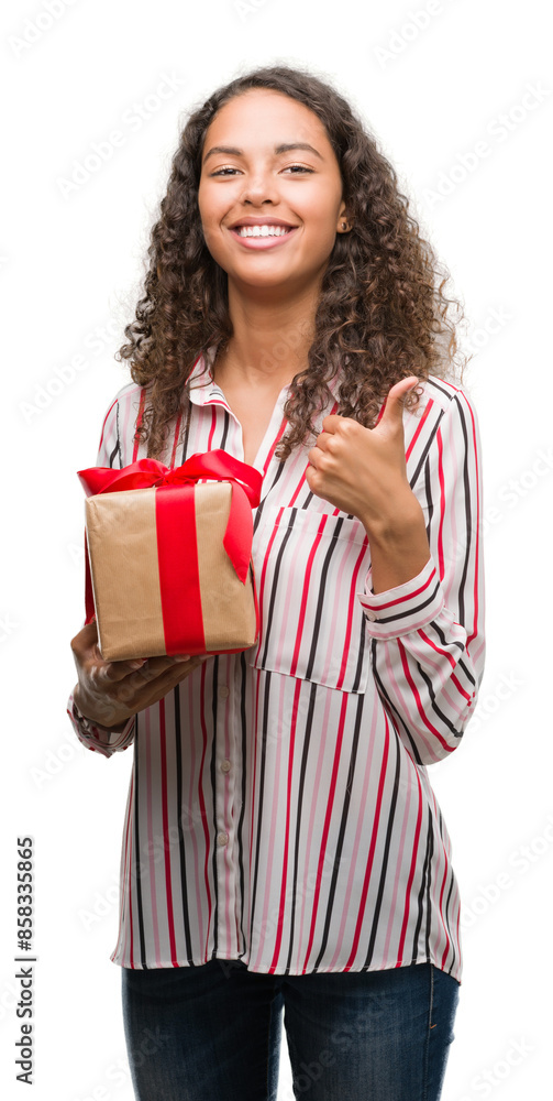 Young hispanic woman in love holding present happy with big smile doing ok sign, thumb up with fingers, excellent sign Young hispanic woman in love holding present happy with big smile doing ok sign, thumb up with fingers, excellent sign