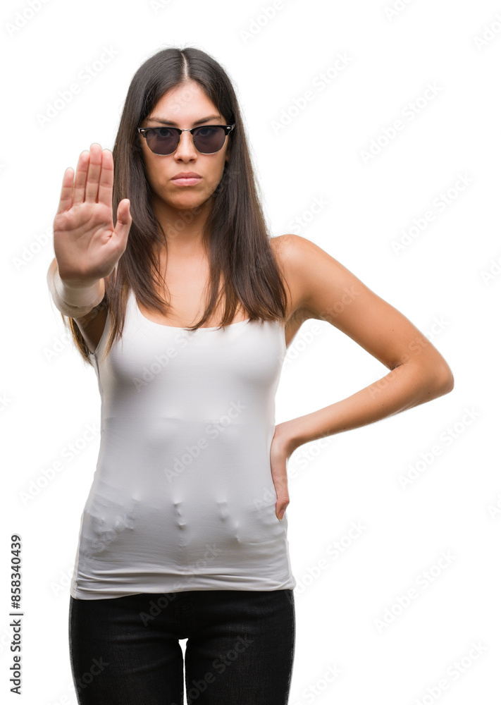 Young beautiful hispanic wearing sunglasses doing stop sing with palm of the hand. Warning expression with negative and serious gesture on the face. Young beautiful hispanic wearing sunglasses doing stop sing with palm of the hand. Warning expression with negative and serious gesture on the face.