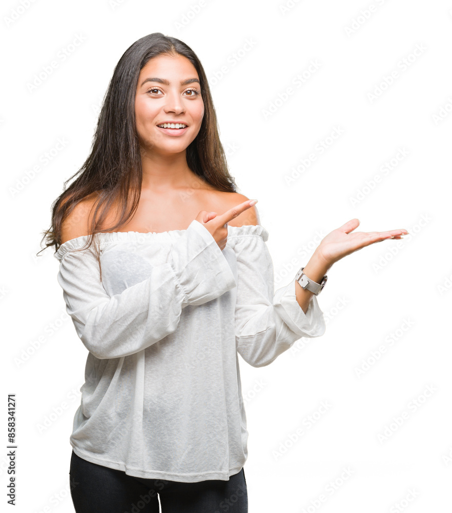 Young beautiful arab woman over isolated background amazed and smiling to the camera while presenting with hand and pointing with finger. Young beautiful arab woman over isolated background amazed and smiling to the camera while presenting with hand and pointing with finger.