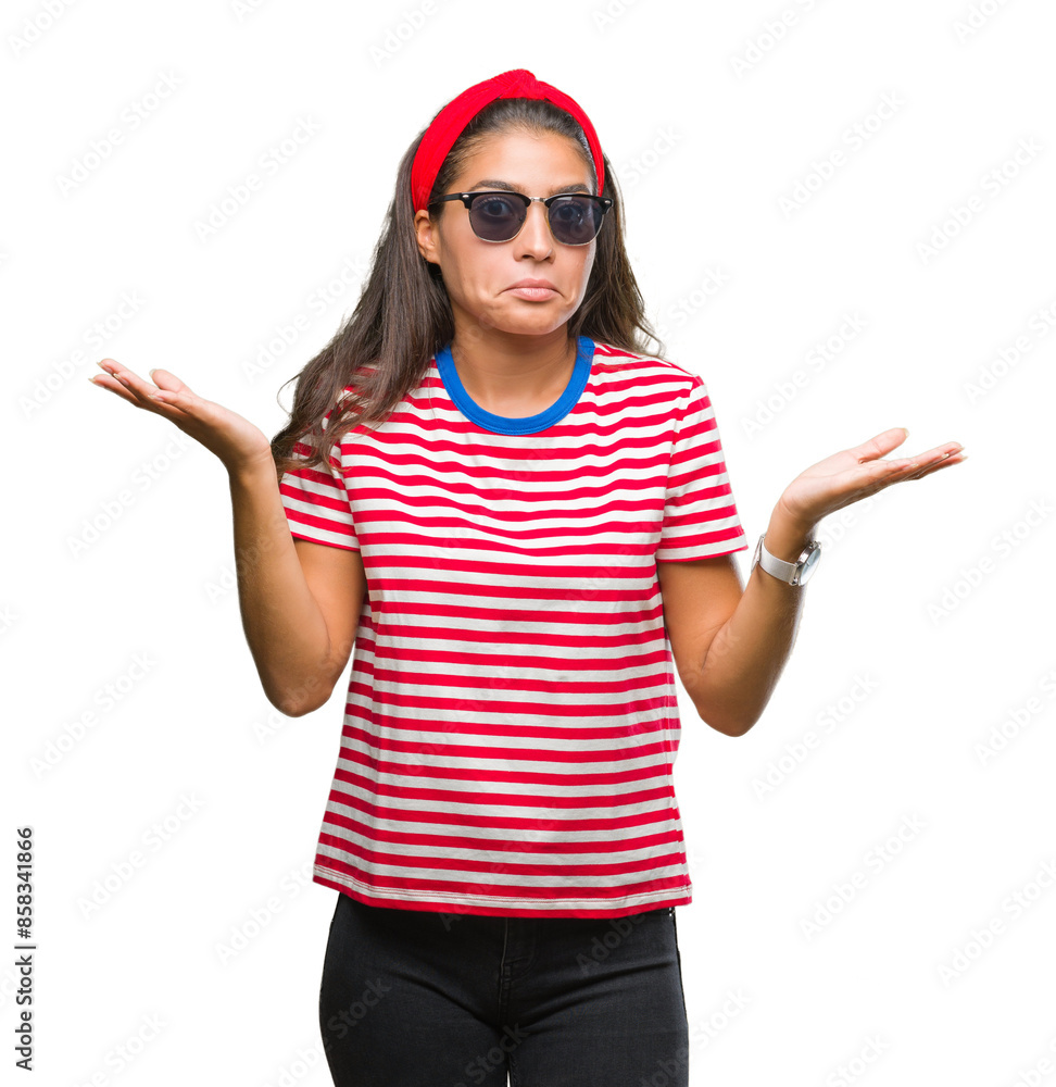 Young beautiful arab woman wearing sunglasses over isolated background clueless and confused expression with arms and hands raised. Doubt concept. Young beautiful arab woman wearing sunglasses over isolated background clueless and confused expression with arms and hands raised. Doubt concept.