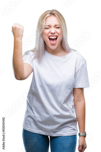 Young blonde woman over isolated background angry and mad raising fist frustrated and furious while shouting with anger. Rage and aggressive concept.