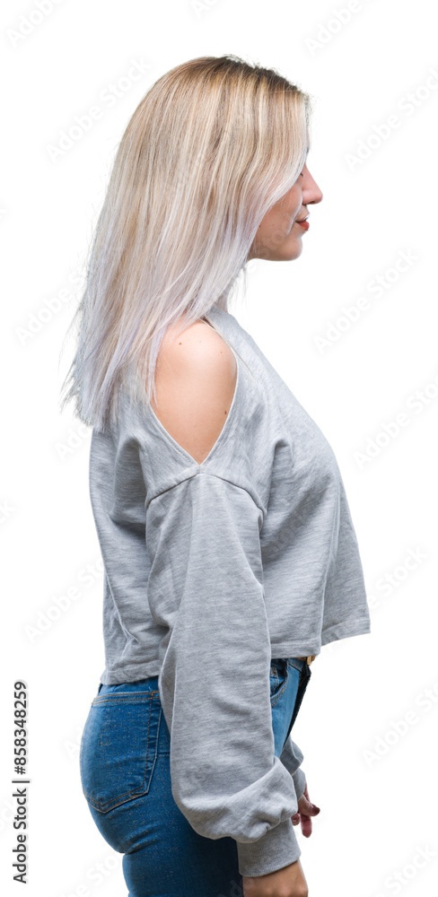 Young blonde woman over isolated background looking to side, relax profile pose with natural face with confident smile.