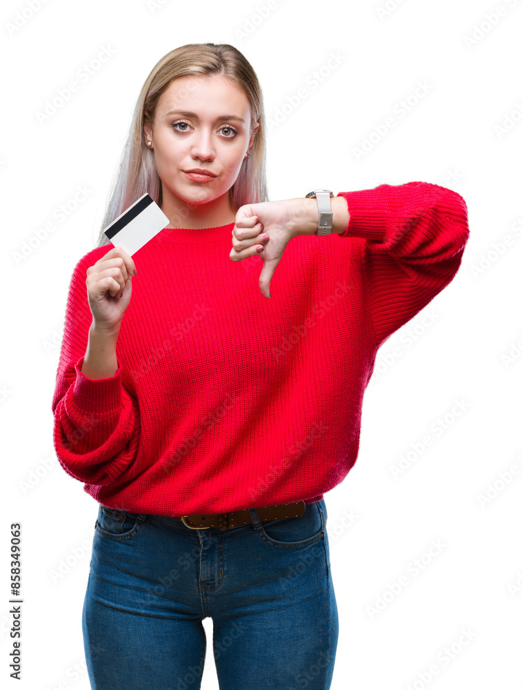 Young blonde woman holding credit card over isolated background with angry face, negative sign showing dislike with thumbs down, rejection concept Young blonde woman holding credit card over isolated background with angry face, negative sign showing dislike with thumbs down, rejection concept
