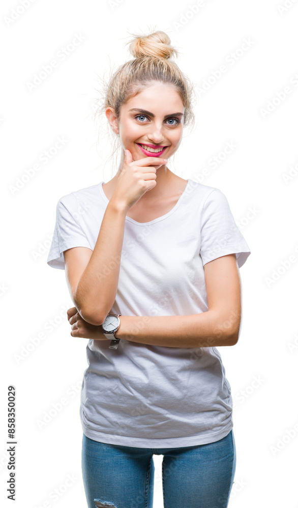 Young beautiful blonde woman wearing white t-shirt over isolated background looking confident at the camera with smile with crossed arms and hand raised on chin. Thinking positive. Young beautiful blonde woman wearing white t-shirt over isolated background looking confident at the camera with smile with crossed arms and hand raised on chin. Thinking positive.