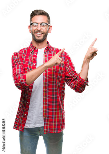 Young handsome man over isolated background smiling and looking at the camera pointing with two hands and fingers to the side.