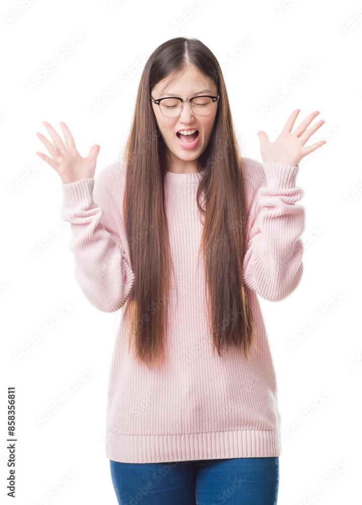 Young Chinese woman over isolated background wearing glasses celebrating mad and crazy for success with arms raised and closed eyes screaming excited. Winner concept Young Chinese woman over isolated background wearing glasses celebrating mad and crazy for success with arms raised and closed eyes screaming excited. Winner concept
