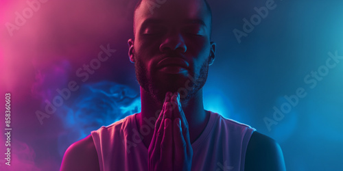 Handsome black man in prayer. Unique prayer concept with a fantasy vibrant ethereal colorful approach. Conceptual image of prayer and thankfulness. With copy space. Glowing light of god.