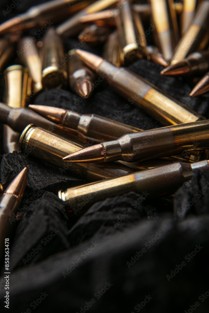 Naklejka premium Cartridges for automatic carbine caliber .223 on charcoal. Ammunition for automatic and semi-automatic rifles. Dark back