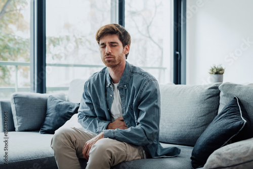 Slika na platnu Sick young man in pain holding belly stomach feeling hurt abdomen ache gastritis pancreatitis symptoms or diarrhea, upset adult suffering from indigestion flatulence abdominal problem concept