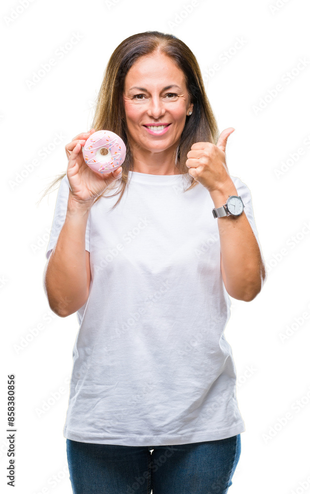 Middle age hispanic woman eating pink donut over isolated background happy with big smile doing ok sign, thumb up with fingers, excellent sign Middle age hispanic woman eating pink donut over isolated background happy with big smile doing ok sign, thumb up with fingers, excellent sign