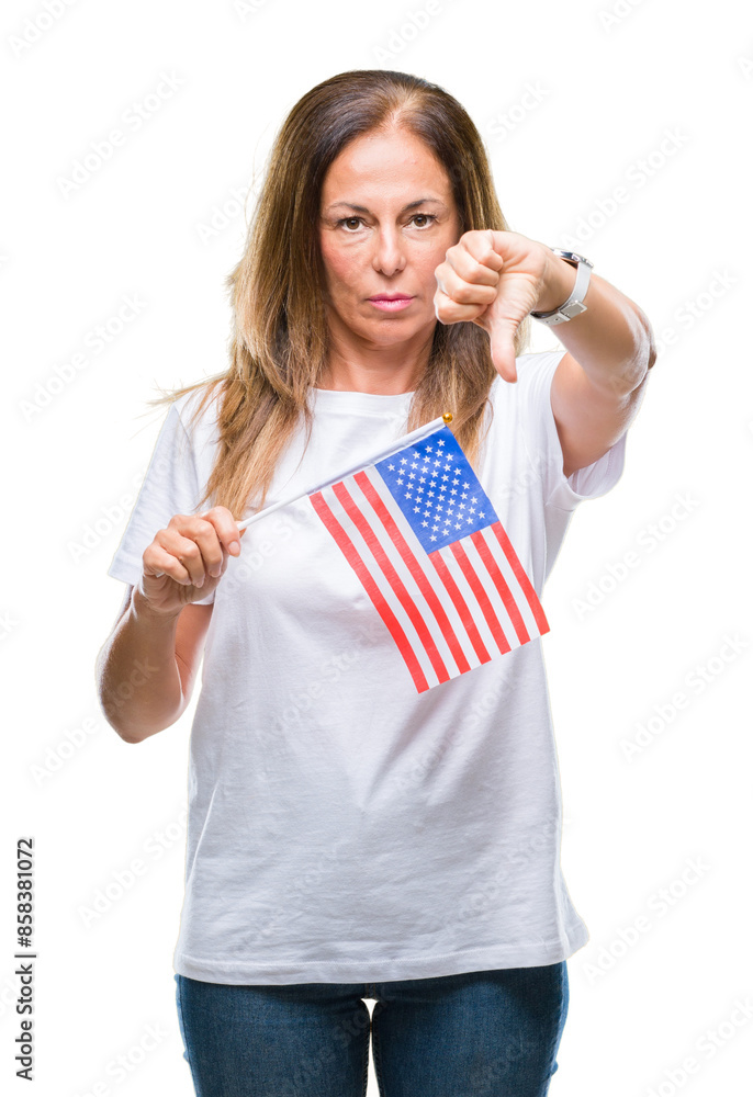 Middle age hispanic woman holding flag of United States of America over isolated background with angry face, negative sign showing dislike with thumbs down, rejection concept Middle age hispanic woman holding flag of United States of America over isolated background with angry face, negative sign showing dislike with thumbs down, rejection concept
