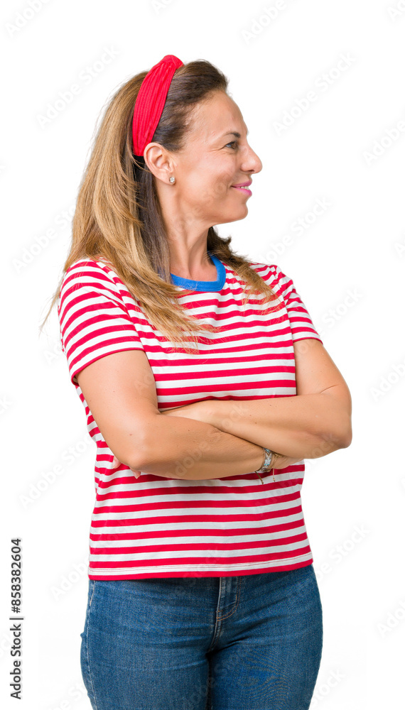 Beautiful middle age woman wearing casual stripes t-shirt over isolated background smiling looking to the side with arms crossed convinced and confident Beautiful middle age woman wearing casual stripes t-shirt over isolated background smiling looking to the side with arms crossed convinced and confident