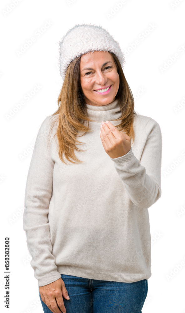 Beautiful middle age woman wearing winter sweater and hat over isolated background Beckoning come here gesture with hand inviting happy and smiling