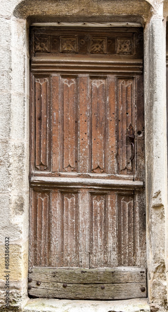 Old wooden door in a stoned ancient frame