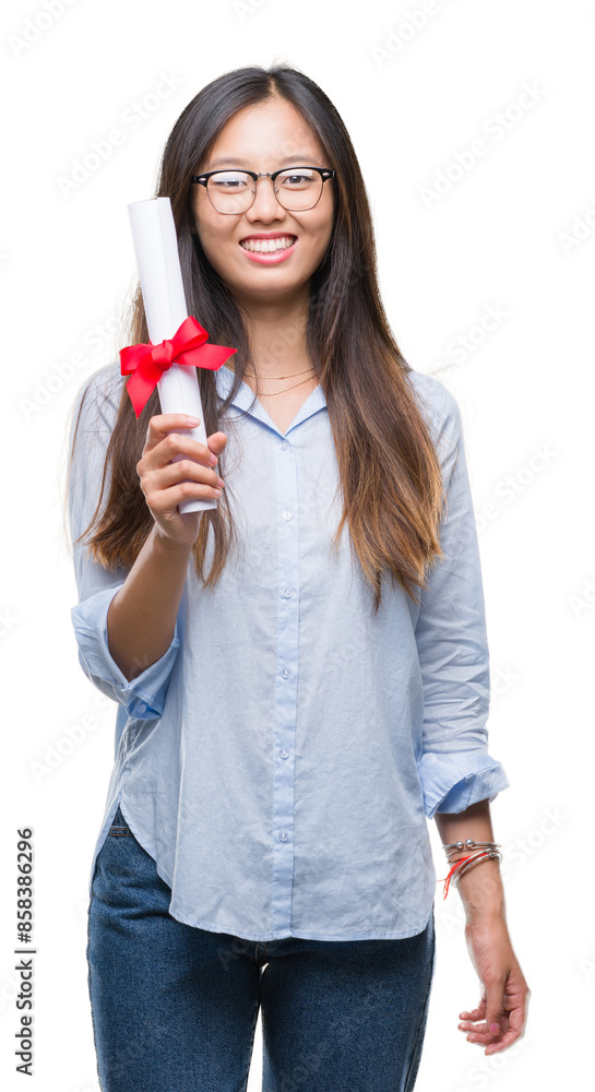 Young asian woman holding degree over isolated background with a happy face standing and smiling with a confident smile showing teeth Young asian woman holding degree over isolated background with a happy face standing and smiling with a confident smile showing teeth