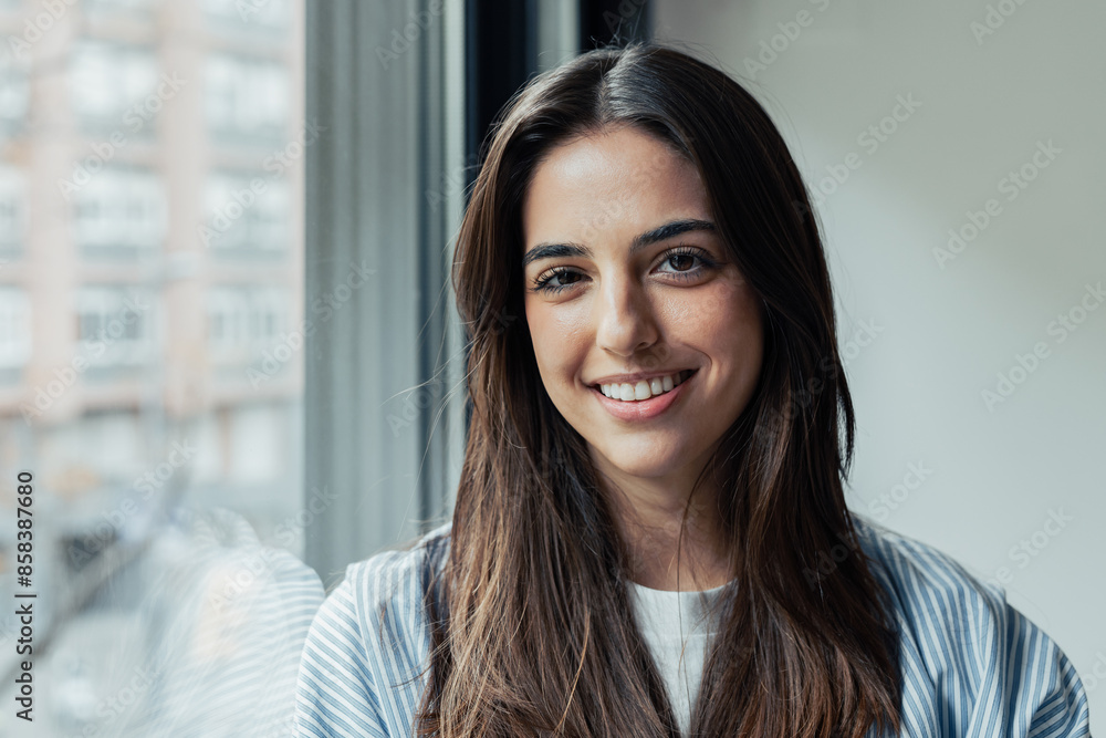 Head shot portrait confident positive woman with healthy toothy smile looking at camera, standing near window, successful happy businesswoman entrepreneur student posing for profile picture. Head shot portrait confident positive woman with healthy toothy smile looking at camera, standing near window, successful happy businesswoman entrepreneur student posing for profile picture.