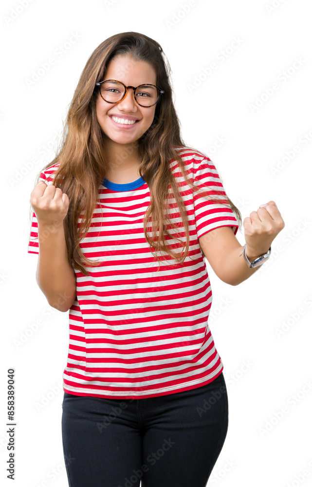 Young beautiful brunette woman wearing glasses and stripes t-shirt over isolated background very happy and excited doing winner gesture with arms raised, smiling and screaming for success. Celebration Young beautiful brunette woman wearing glasses and stripes t-shirt over isolated background very happy and excited doing winner gesture with arms raised, smiling and screaming for success. Celebration