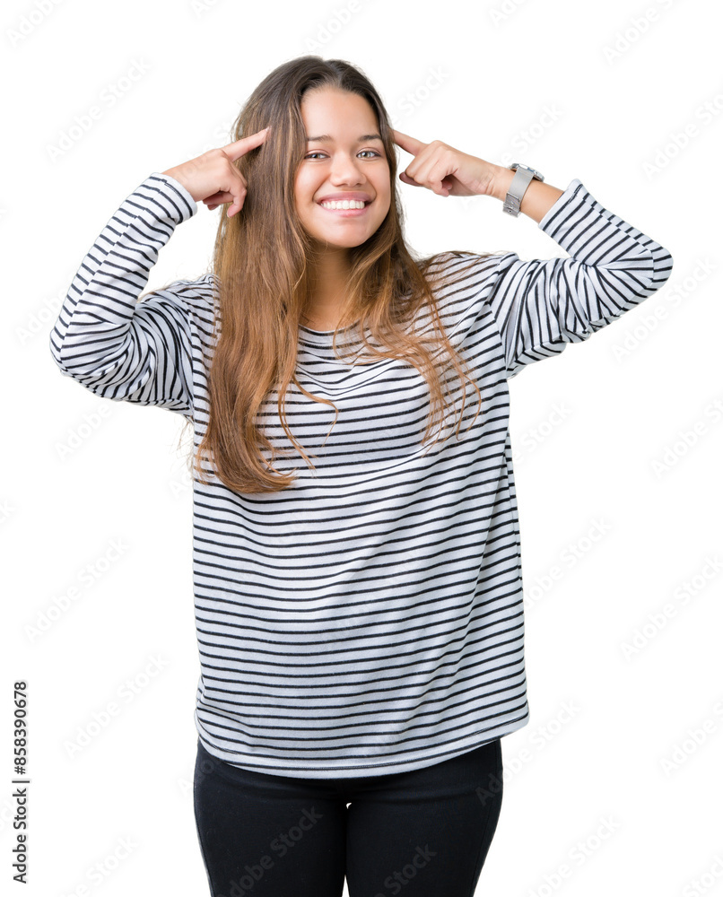 Young beautiful brunette woman wearing stripes sweater over isolated background Smiling pointing to head with both hands finger, great idea or thought, good memory Young beautiful brunette woman wearing stripes sweater over isolated background Smiling pointing to head with both hands finger, great idea or thought, good memory