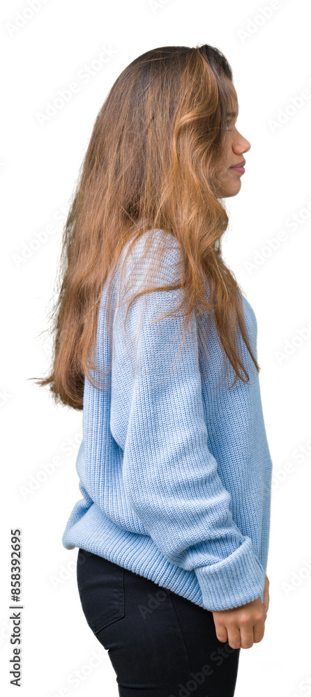 Young beautiful brunette woman wearing blue winter sweater over isolated background looking to side, relax profile pose with natural face with confident smile. Young beautiful brunette woman wearing blue winter sweater over isolated background looking to side, relax profile pose with natural face with confident smile.