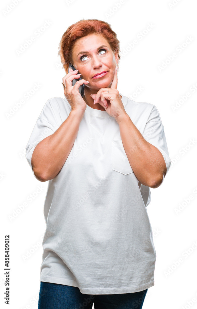 Atrractive senior caucasian redhead woman talking on smartphone over isolated background serious face thinking about question, very confused idea Atrractive senior caucasian redhead woman talking on smartphone over isolated background serious face thinking about question, very confused idea