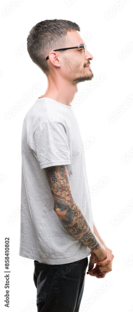 Young tattooed adult man looking to side, relax profile pose with natural face with confident smile. Young tattooed adult man looking to side, relax profile pose with natural face with confident smile.
