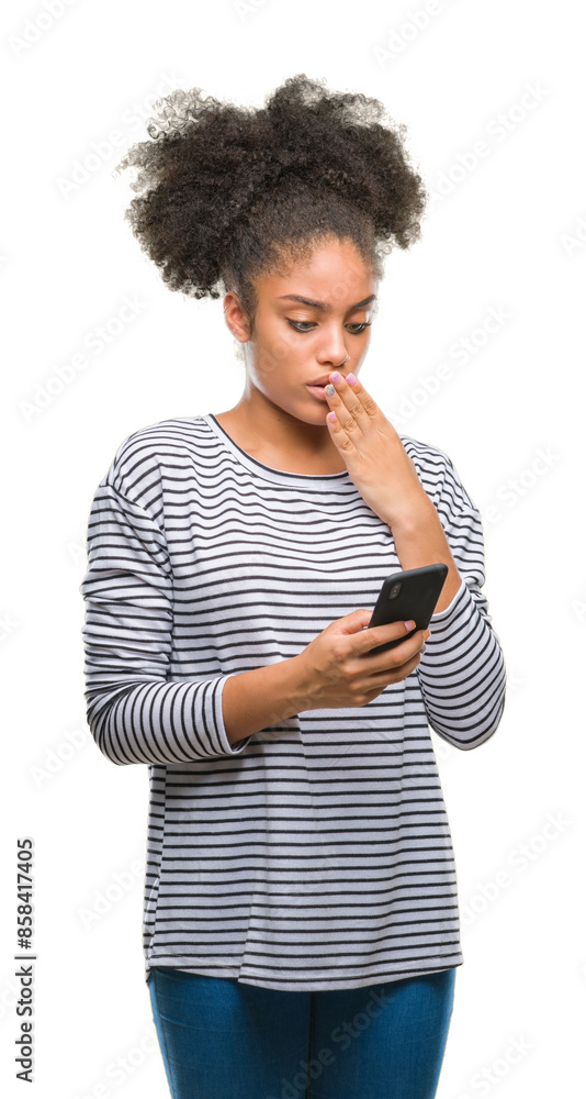 Young afro american woman texting using smartphone over isolated background cover mouth with hand shocked with shame for mistake, expression of fear, scared in silence, secret concept Young afro american woman texting using smartphone over isolated background cover mouth with hand shocked with shame for mistake, expression of fear, scared in silence, secret concept