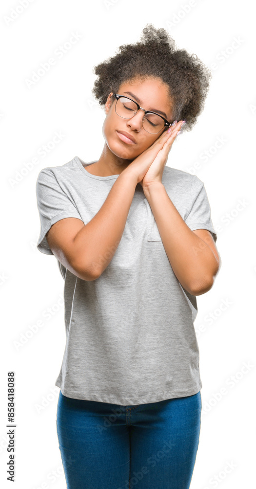 Young afro american woman wearing glasses over isolated background sleeping tired dreaming and posing with hands together while smiling with closed eyes. Young afro american woman wearing glasses over isolated background sleeping tired dreaming and posing with hands together while smiling with closed eyes.