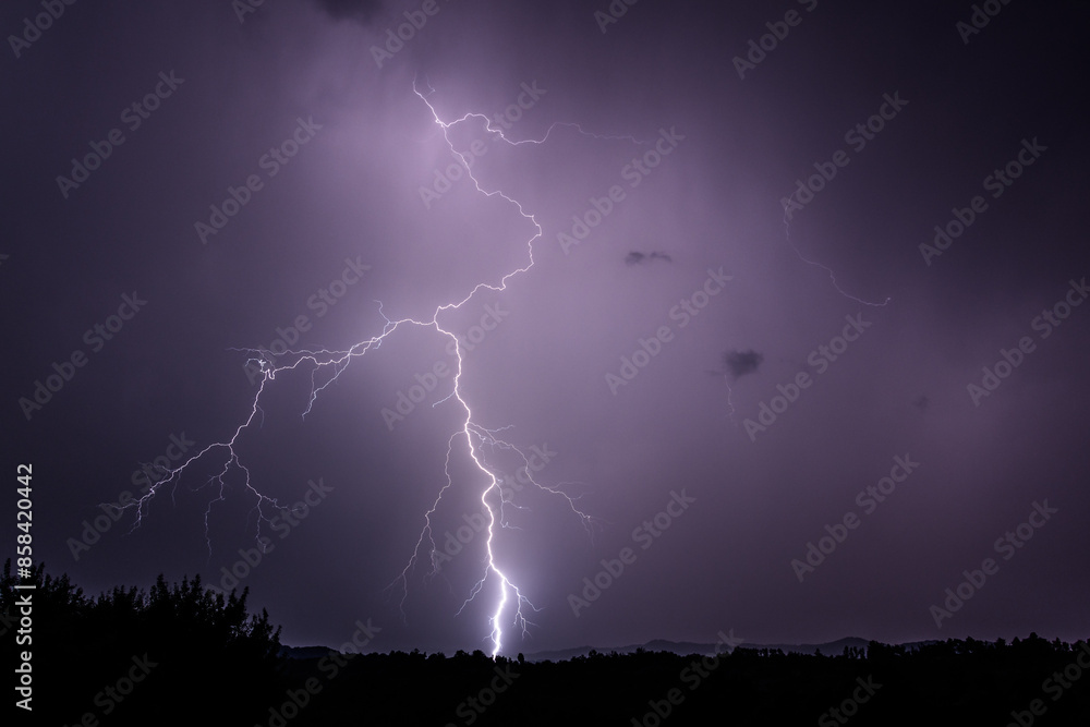 Powerful lightning strike in a bright purple sky Powerful lightning strike in a bright purple sky
